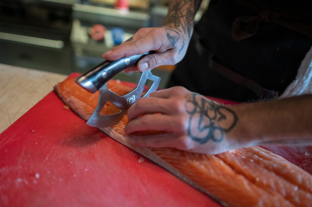 ulu knife being used to trim a piece of fish