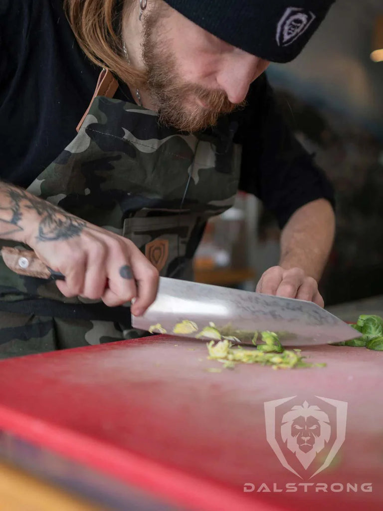 A photo of a man chopping a vegetable using the Chef's Knife 9.5" | Firestorm Alpha Series | Dalstrong