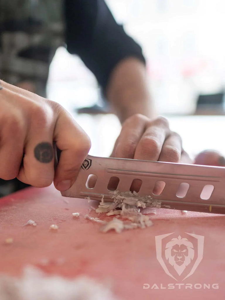 A man's hand mincing an onion using the Nakiri Asian Vegetable Knife 6" | Offset Blade | Gladiator Series | NSF Certified | Dalstrong