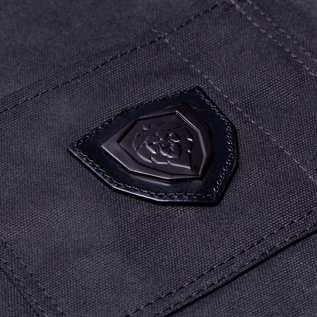 Dark leather lion logo stitched on to the pocket of a chef apron