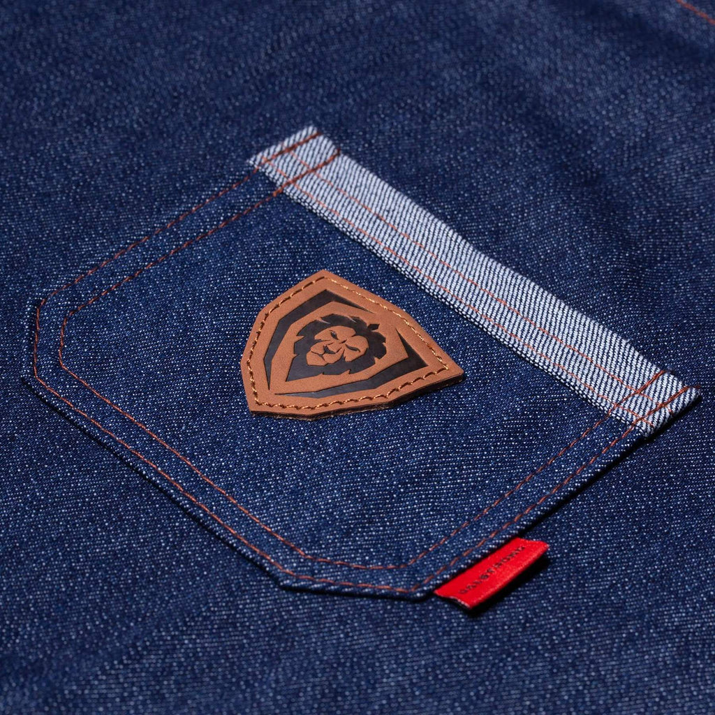 Close up on a blue apron's pocket with a brown Dalstrong lion logo