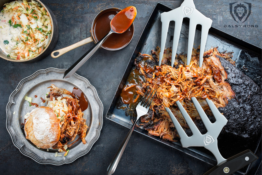 A tray of pulled brisket with meat shredding claws on top next to sauces 