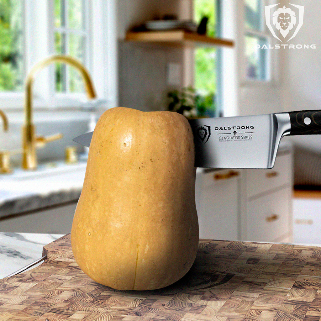 A kitchen knife slicing through a butternut squash on a cutting board