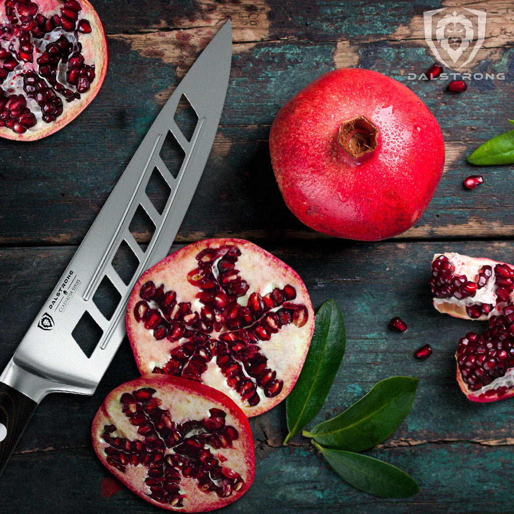 Vegetable slicing knife with hollow grooves next to a sliced pomegranate