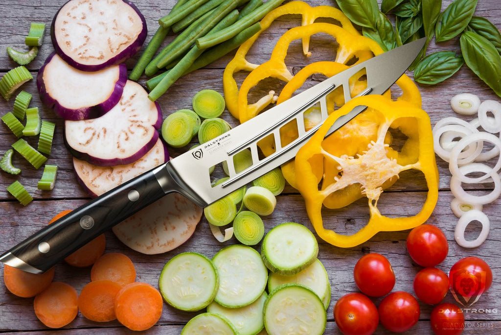 Dalstrong vegetable knife on a pule of chopped vegetables including peppers