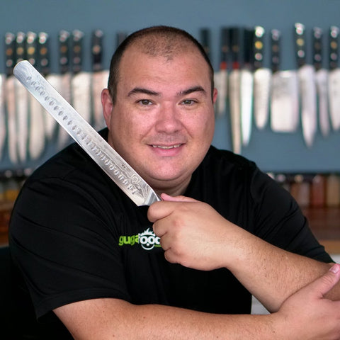 Guga Foods holding a Dalstrong Shogun Series 12'' Slicing & Carving Knife