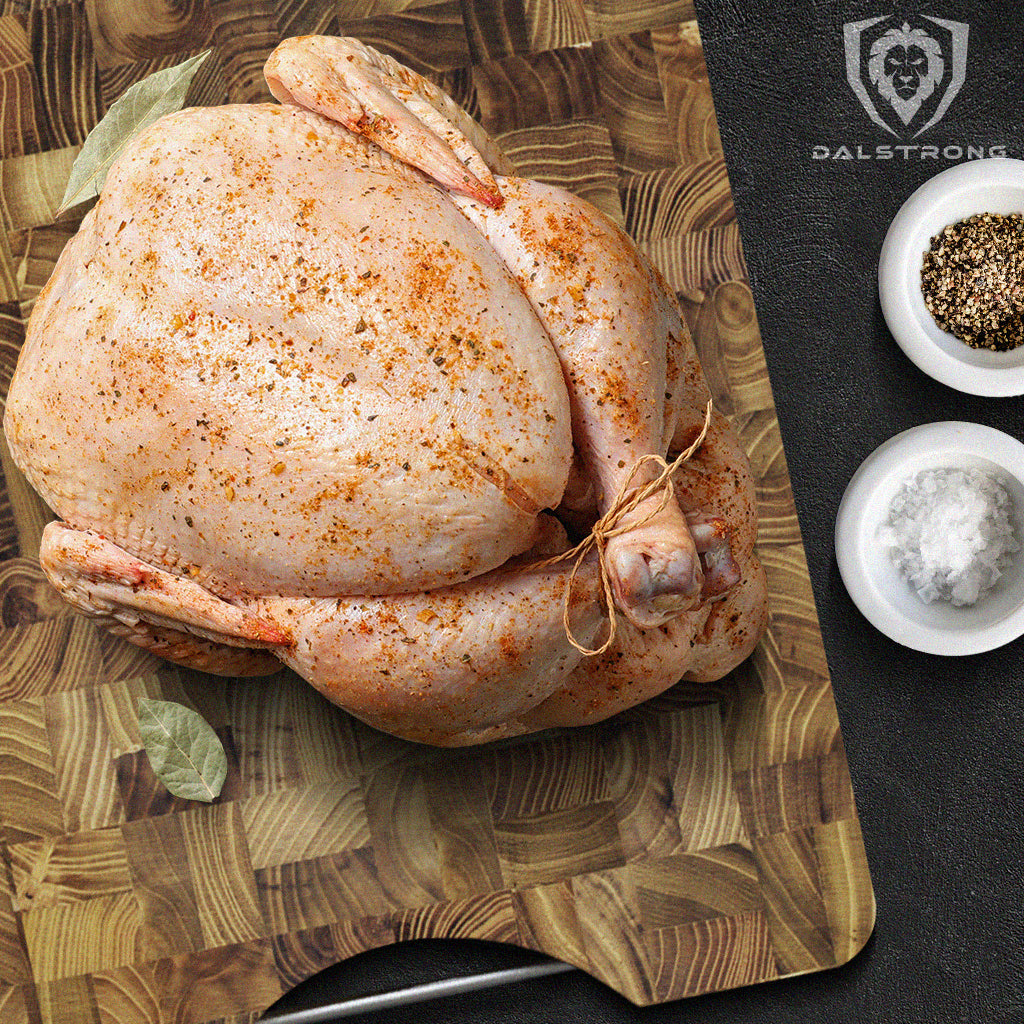 Uncooked seasoned turkey on a large cutting board with a steel handle