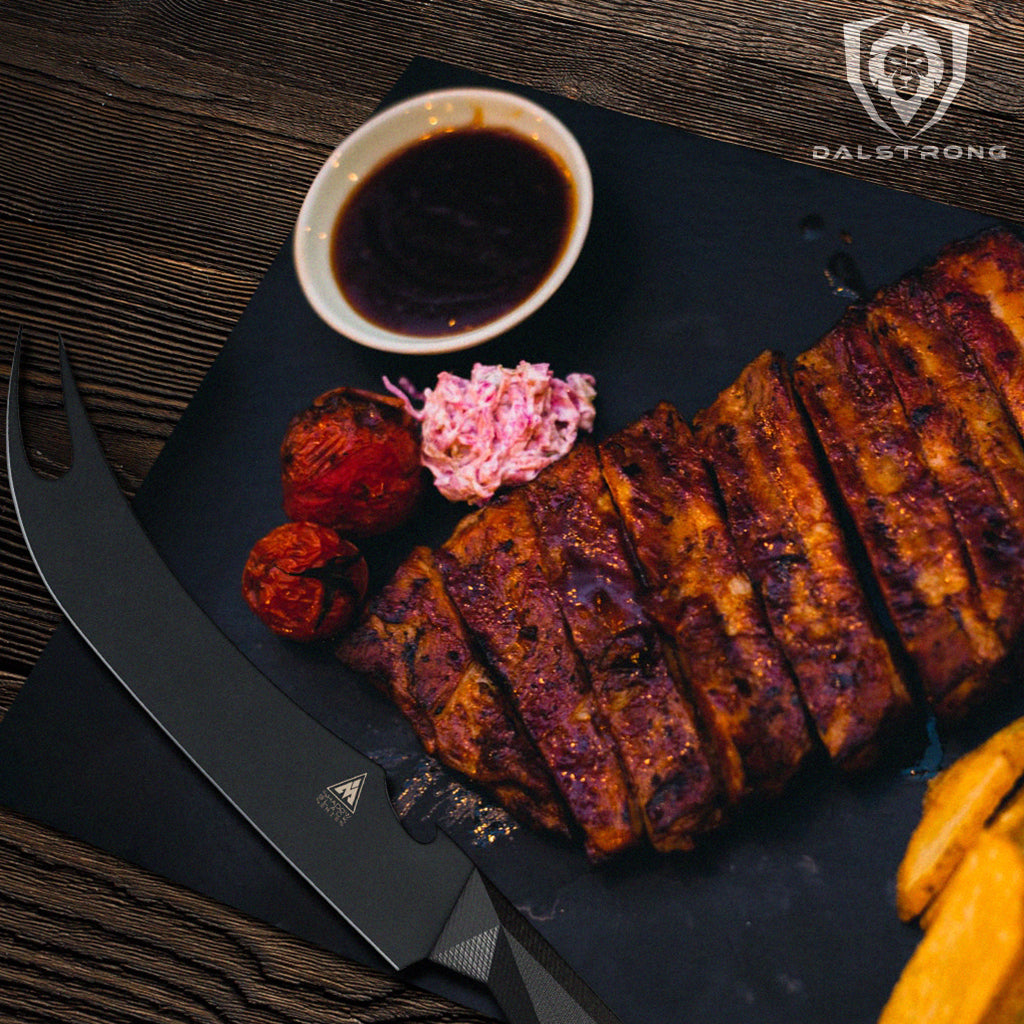 A black bbq knife with a pronged tip next to a rack of cooked ribs and bbq sauce