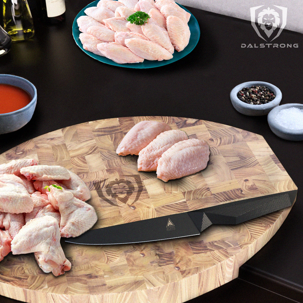 Raw chicken wings on teak cutting board