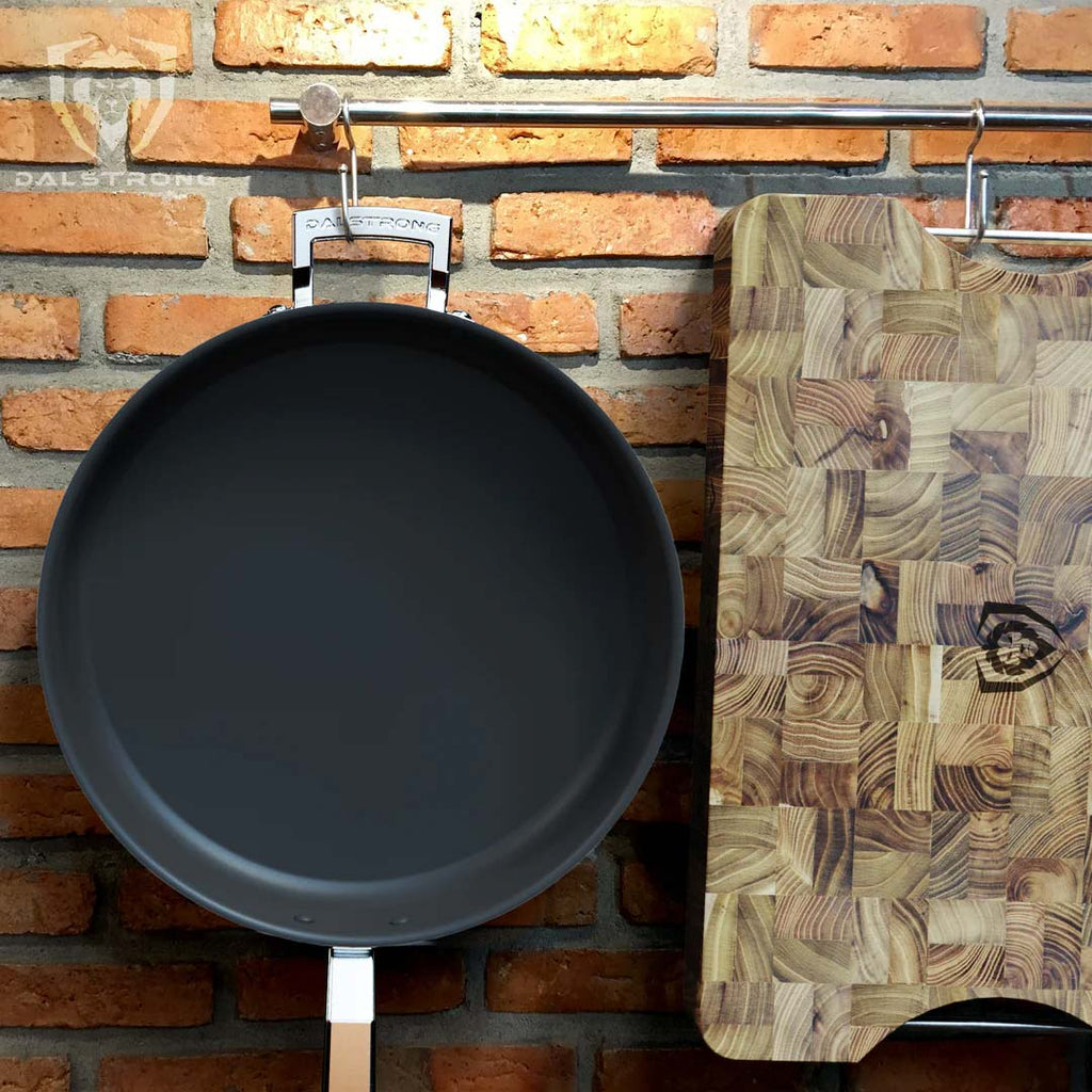 12" Sauté Frying Pan | ETERNA Non-stick | Oberon Series | Dalstrong on the wall with the Dalstrong wooden board.