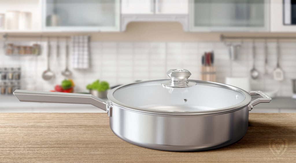 Oberon Series Saute Frying Pan on clean wooden kitchen counter with cooking utensils hanging on a wall in the distance