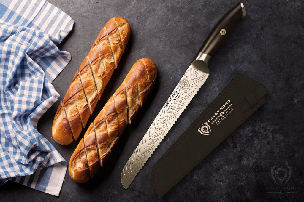 Two bread rolls next to a blue kitchen towel and a stainless steel bread knife on a dark surface