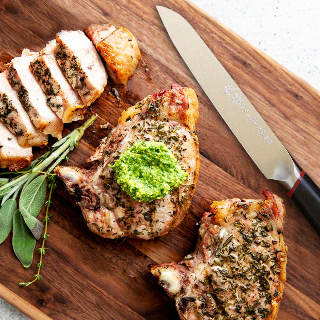 Marinated pork chops next to a kitchen knife on a wooden surface 