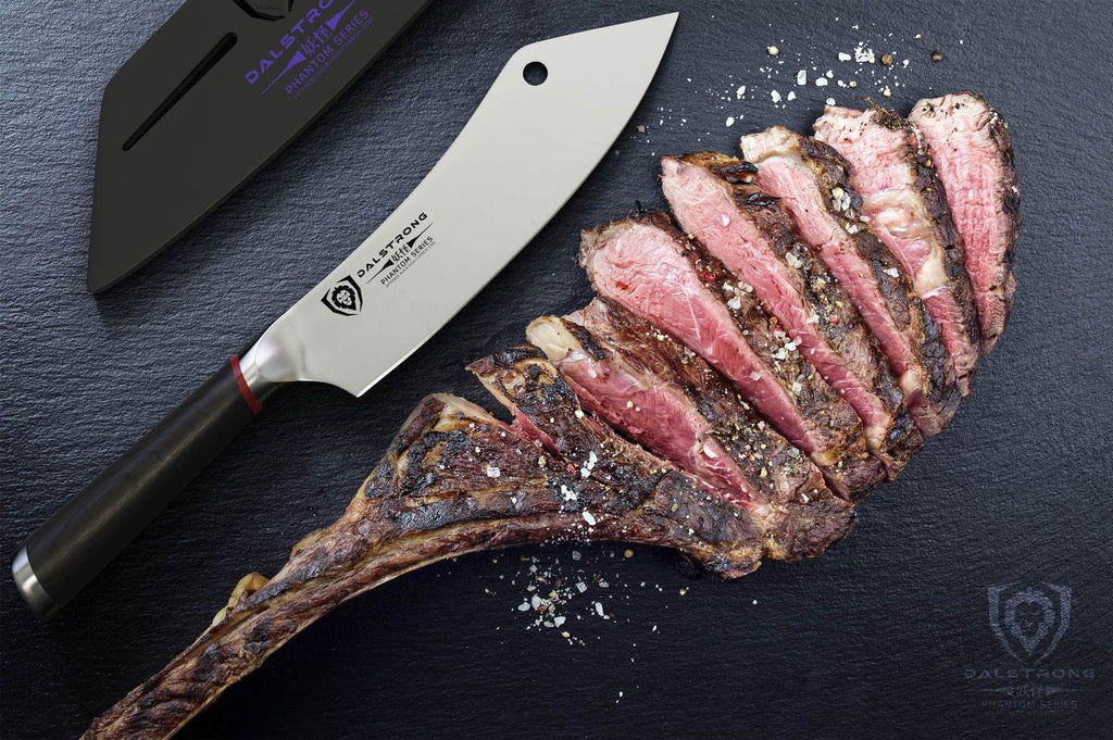 Chinese cleaver next to sliced medium rare meat on a dark surface 
