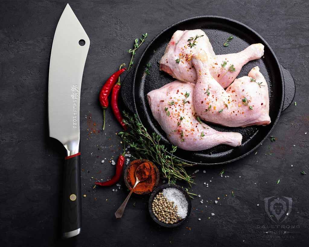 A Chinese cleaver next to uncooked chicken on a black plate 