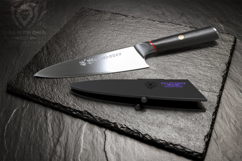 Chef knife with engravings on the blade on black surface next to a dark plastic sheath