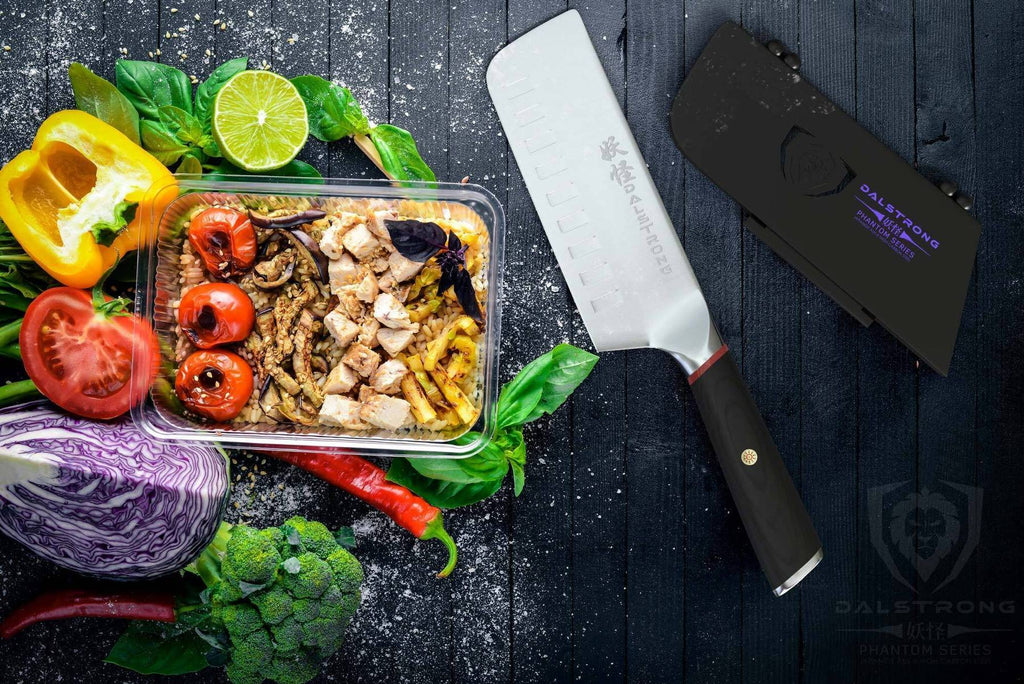 Colorful vegetables on a dark wooden surface next to a nakiri knife