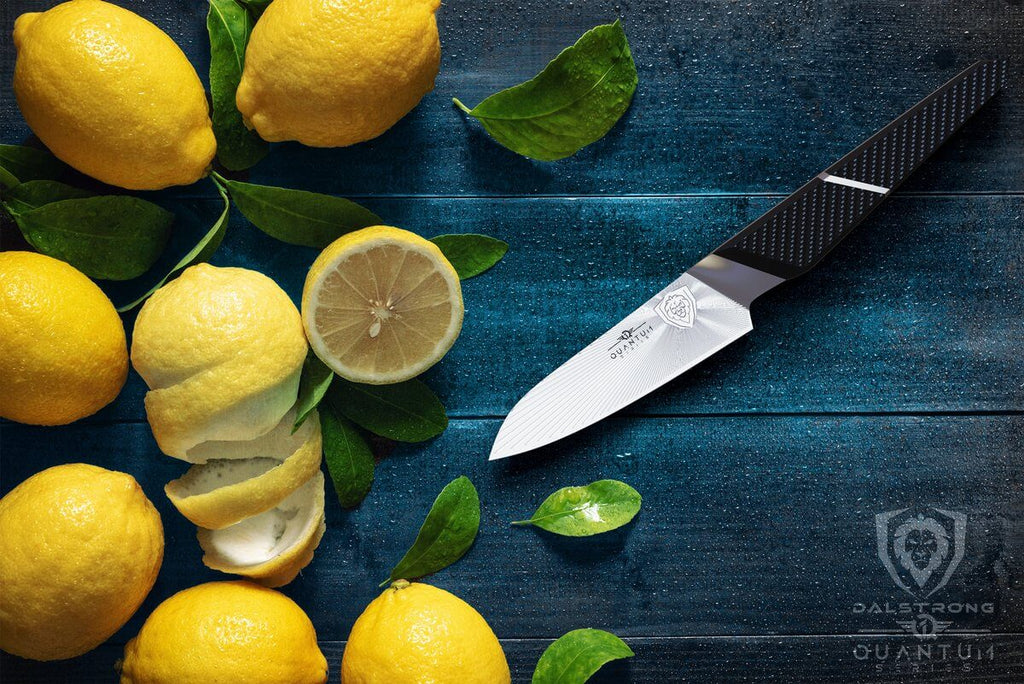 Eight lemons on a blue surface next to a sharp paring knife