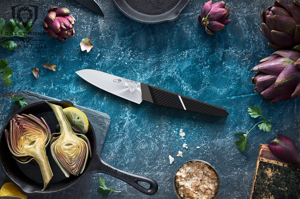 A paring knife against a teal background surrounded by vegetables