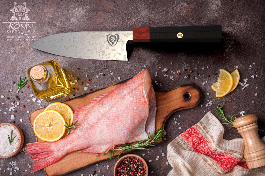 A raw fish on a wooden cutting board next to a sushi knife