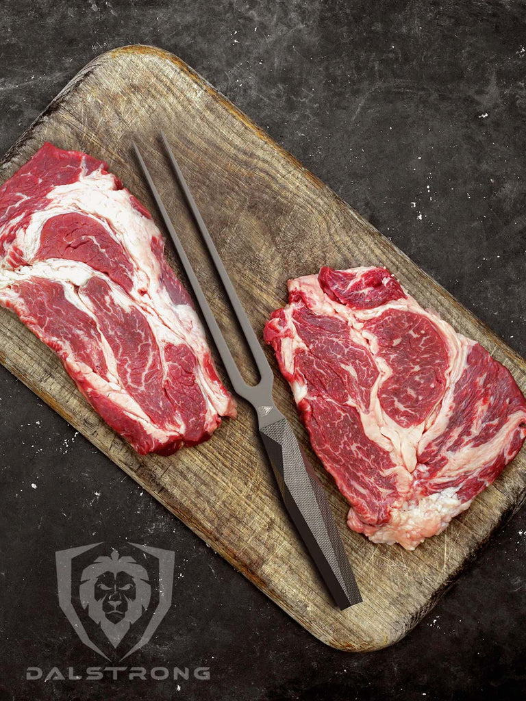 A photo of the Meat Fork 8.5" | Shadow Black Series | NSF Certified | Dalstrong in between two beautiful steaks