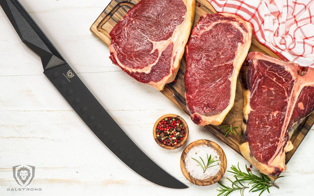 Long black butcher knife next to three piece of red meat 