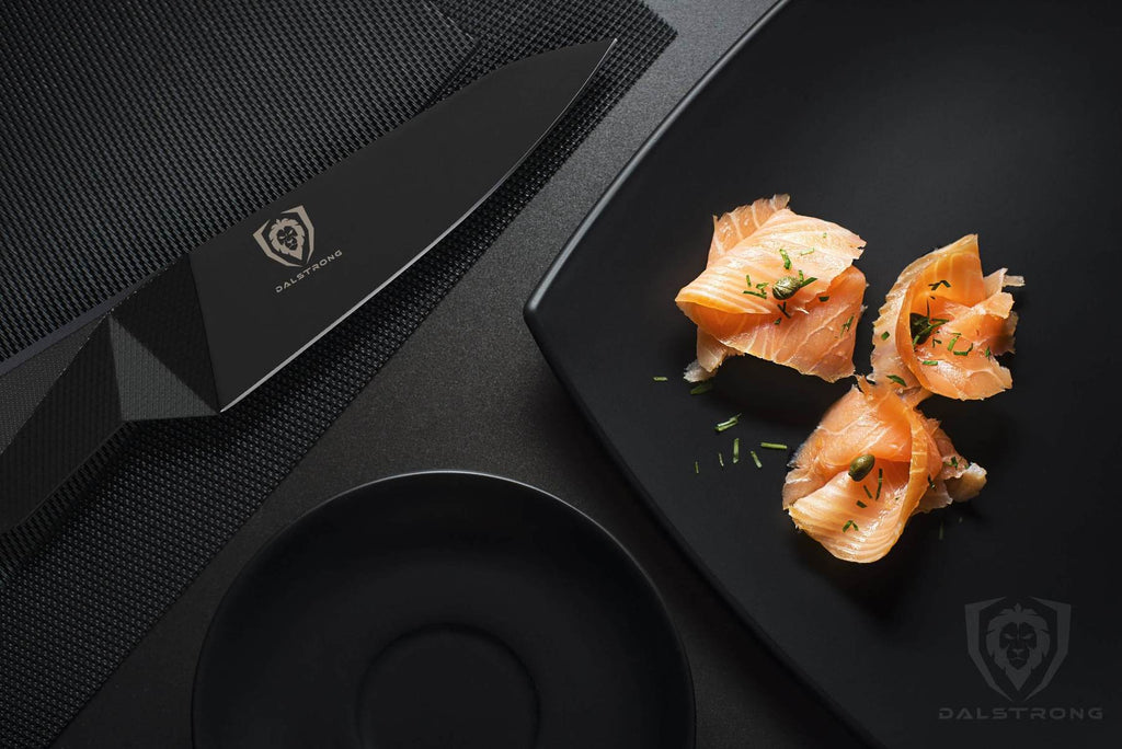 Dark kitchen table with black plate and black paring knife