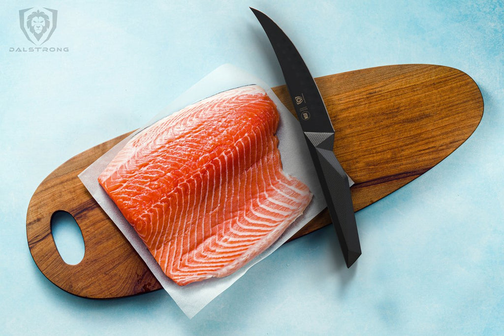 Uncooked fish on a wooden cutting board beside a black fillet knife with a light blue surface