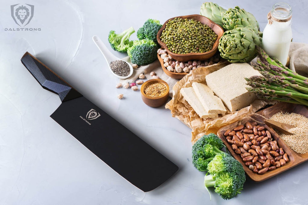 nakiri knife laying beside assorted nuts and veggies