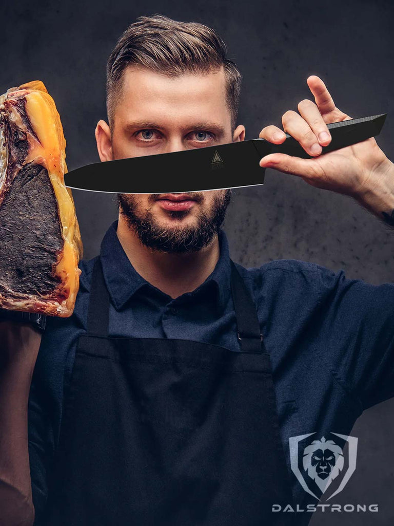 A man with arpron is holding the Chef's Knife 8" | Shadow Black Series | NSF Certified | Dalstrong and a dry aged meat on the other hand