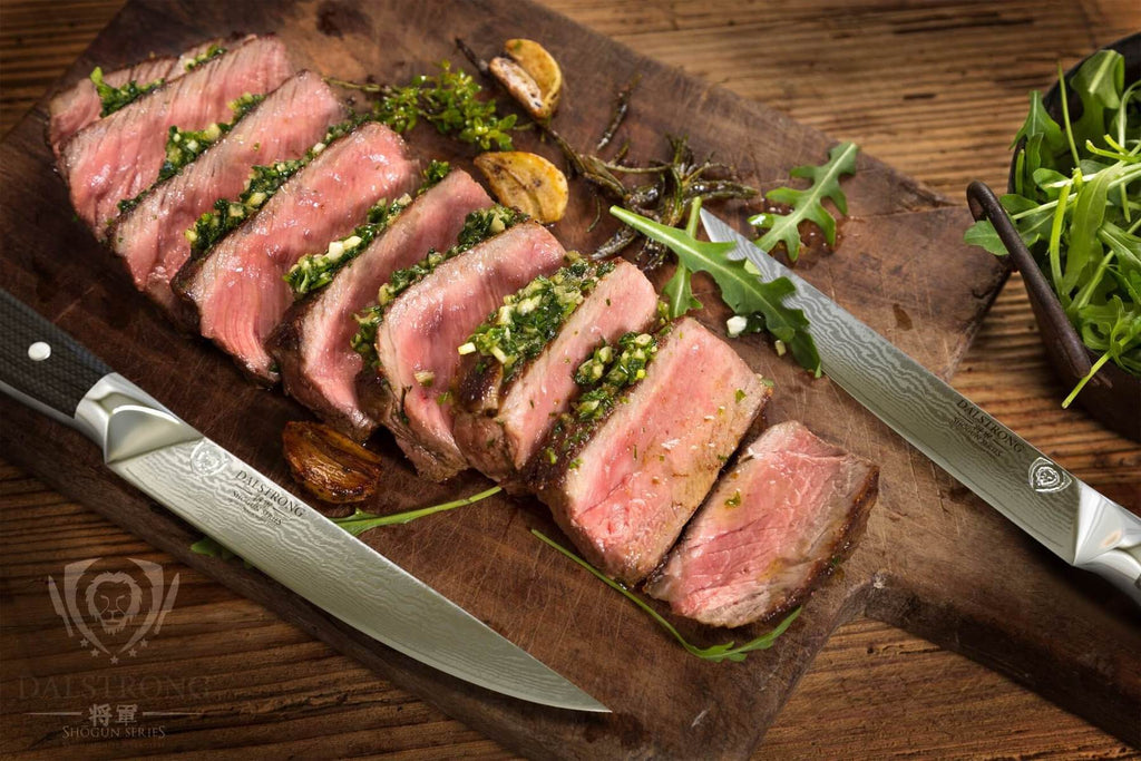 A tray of chopped cooked steak next to two sharp steak knives