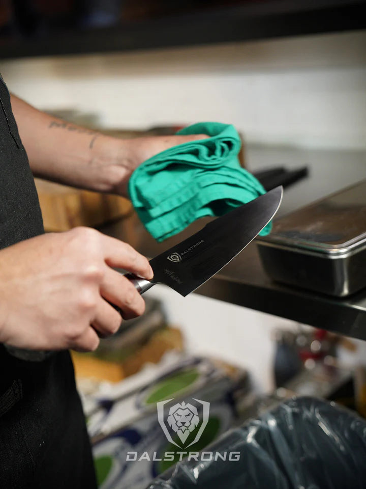 A man holding the Spartan Ghost Series Chef's Knife 8" and a cloth.