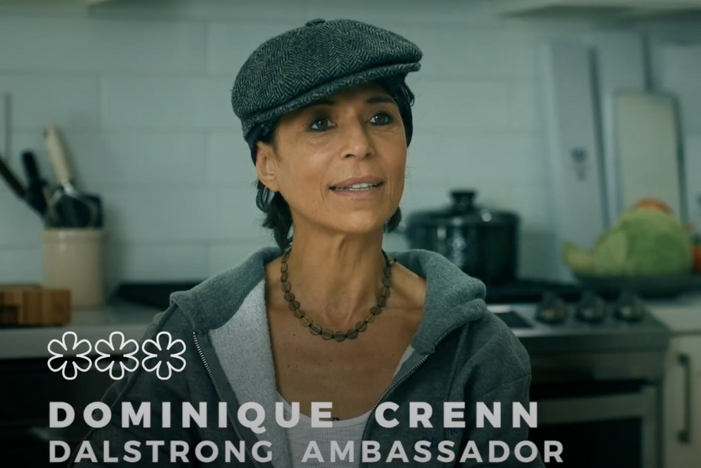 Chef Dominique Crenn sitting down in a kitchen giving an interview with subtitles of her name