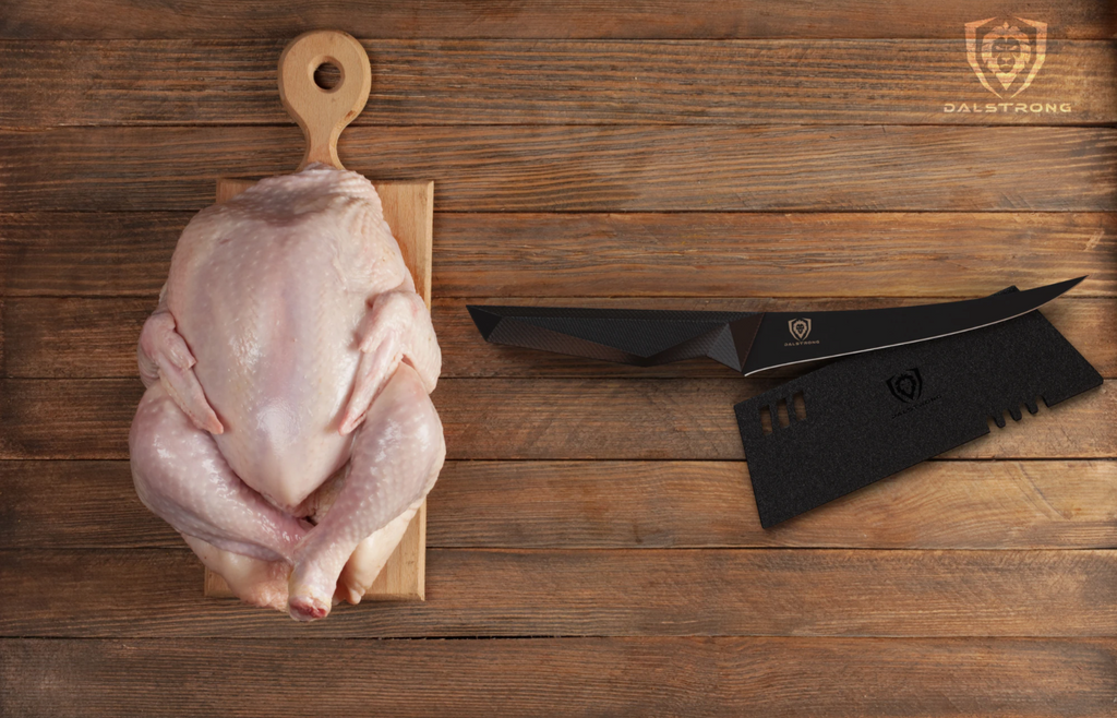 Uncooked chicken on a cutting board next to a black boning knife on a wooden table