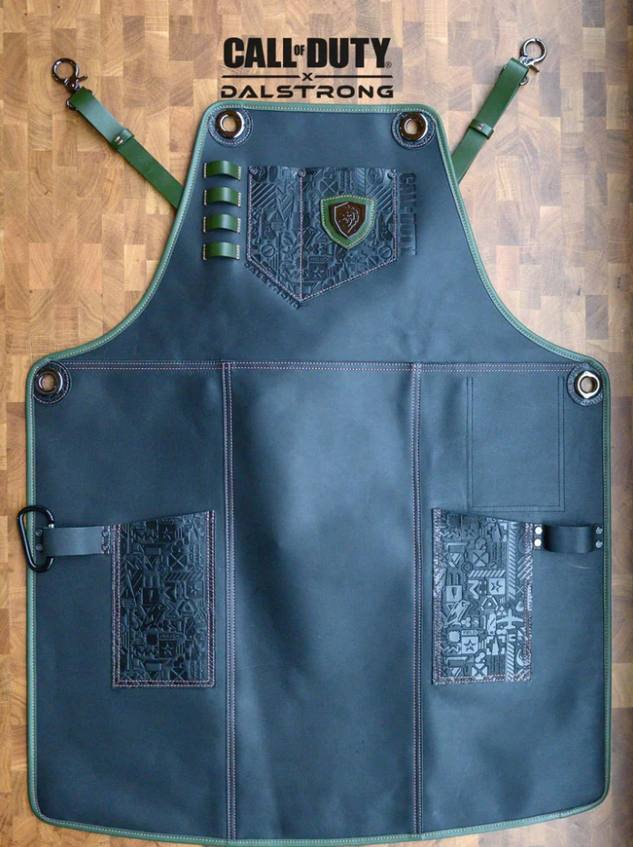 A photo of the Limited Edition Chef Leather Apron Call of Duty © Edition Black Genuine Leather EXCLUSIVE COLLECTOR APRON Dalstrong on top of a wooden board