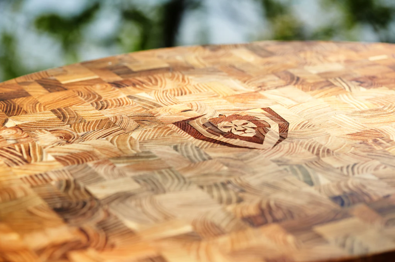 A close-up photo of the Corner Cutting Board Natural Teak Wood Dalstrong