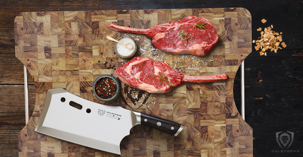 A photo of the Lionswood Colossal Teak Cutting Board Dalstrong with two steaks and a Dalstrong cleaver on top of it.