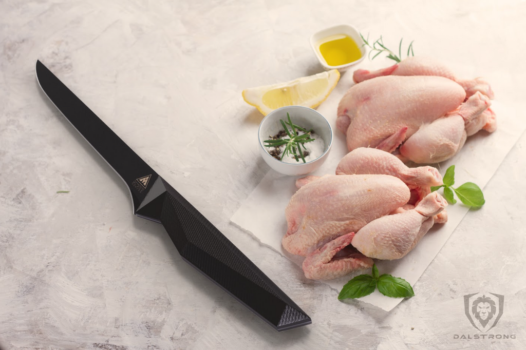 Using kitchen knife to cut raw chicken leg away from flesh