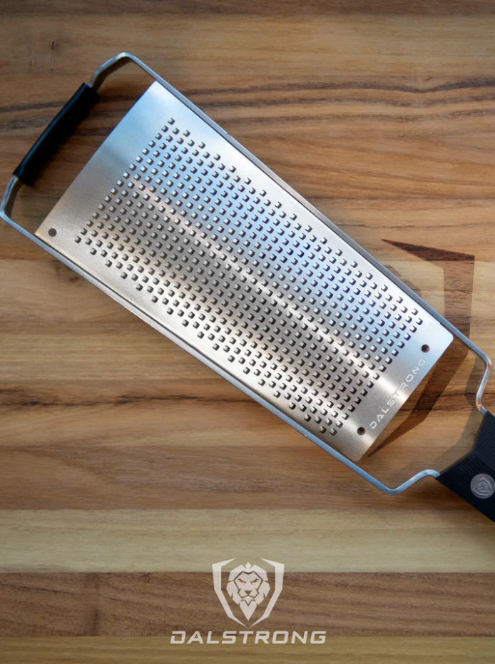 A photo of the Dalstrong Professional Fine Wide Cheese Grater on top of the Dalstrong wooden board.