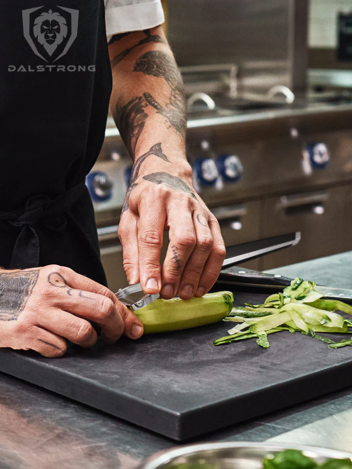 Photo of a man with tattooes peeling a cucumber using the Y Peeler 3 Blades Case | Dalstrong on a board