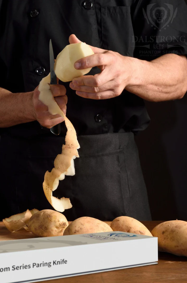 A photo of a man with black shirt peeling a potato using the Paring Knife 4" Phantom Series | Dalstrong