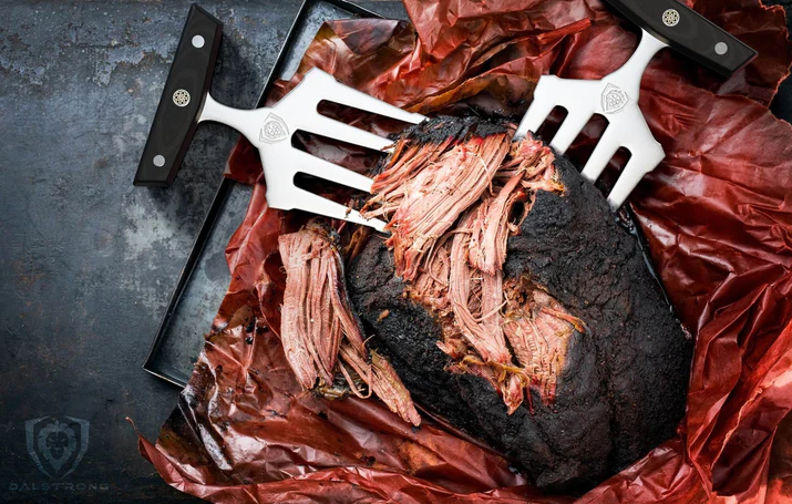 A photo of the Dalstrong Meat Shredding Claws shredding a huge smoked brisket in a wax paper
