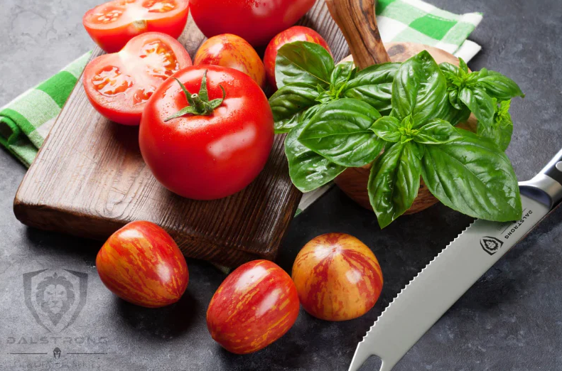 A bunch of sliced tomatoes on a wooden board beside the Gladiator Series | NSF Certified | Dalstrong Serrated Tomato Knife 5"  