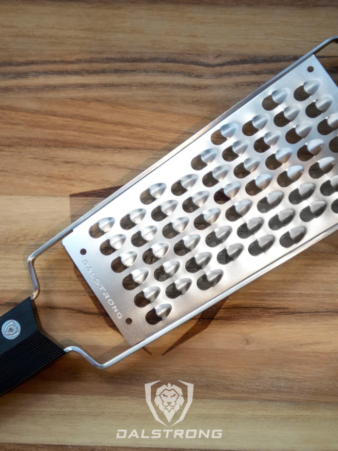 A photo of the Dalstrong Professional Extra Coarse Wide Cheese Grater on top of the Dalstrong wooden board.