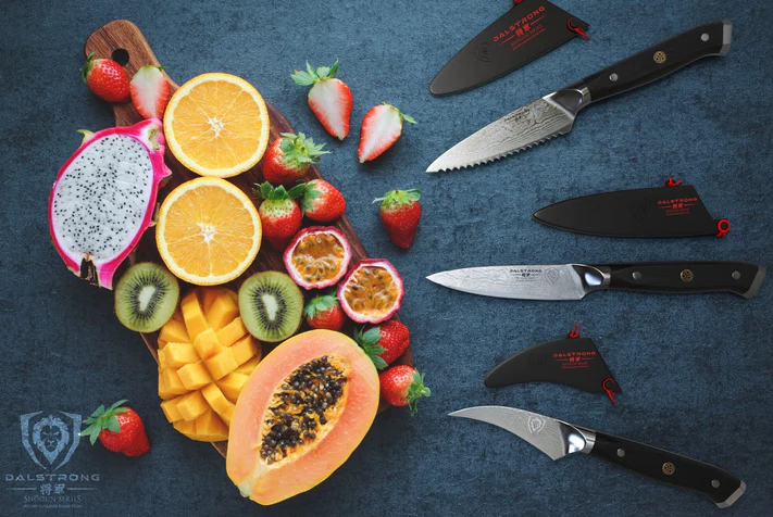 A photo of the 3 Piece Paring Knife Set Shogun Series Elite Dalstrong with a bunch of fresh slices of fruits beside