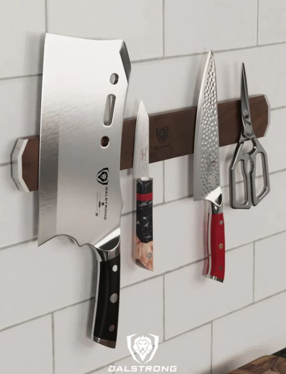 A photo of the Magnetic Bar Walnut Wall Knife Holder Dalstrong with the Dalstrong knives and scissor attached to it on a white wall