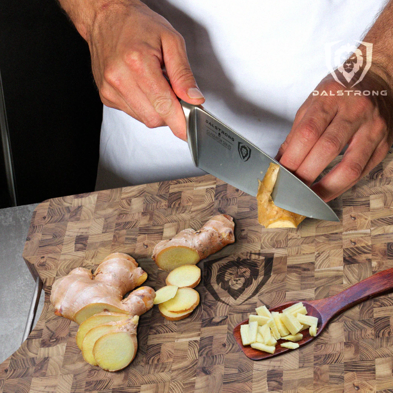 slicing ginger root with a chef's knife on a Dalstrong cutting board