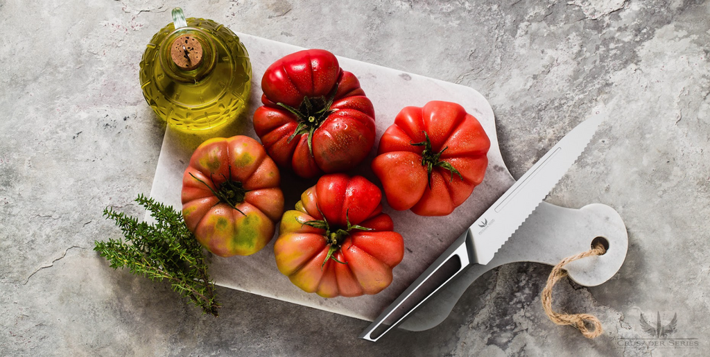 A photo of the Serrated Utility Knife 5.5" Crusader Series | NSF Certified | Dalstrong with four tomatoes on top of a marble board.