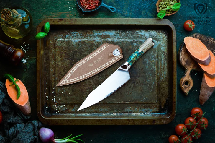 A photo of the Chef's Knife 8" Valhalla Series | Dalstrong with sheath beside it inside an old aluminum tray