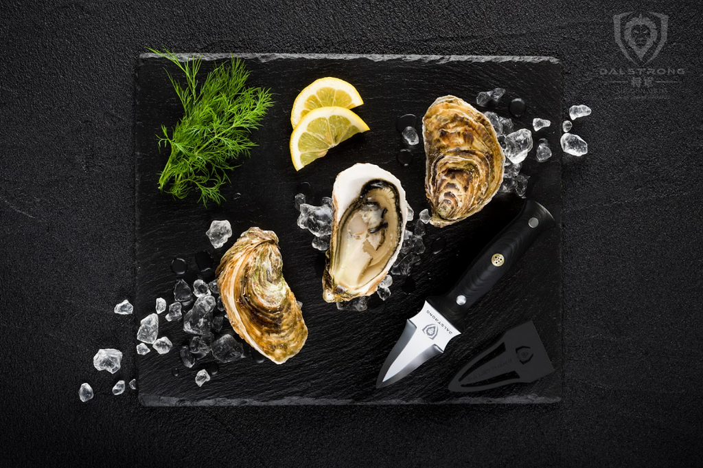 A photo of the Professional Oyster & Clam Shucking Knife 3.5" Shogun Series ELITE | Dalstrong with 3 opened oysters and a lime on top of a marble board